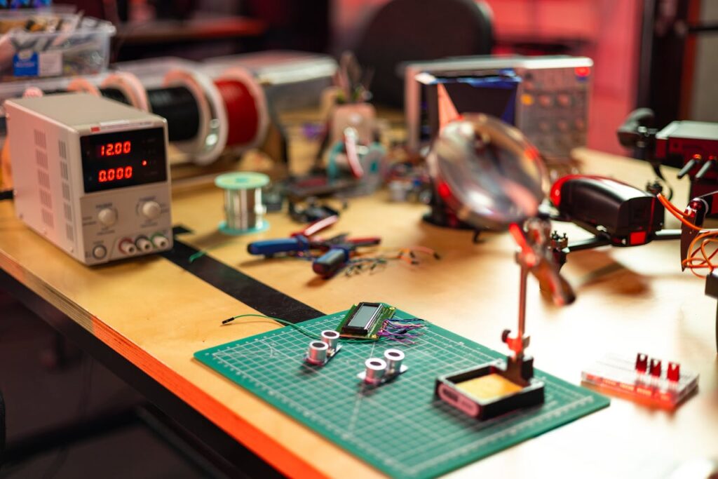 A detailed view of an electronics workshop with various tools and components on a workbench.